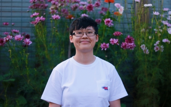 Connie Rabb stands in front of colorful garden