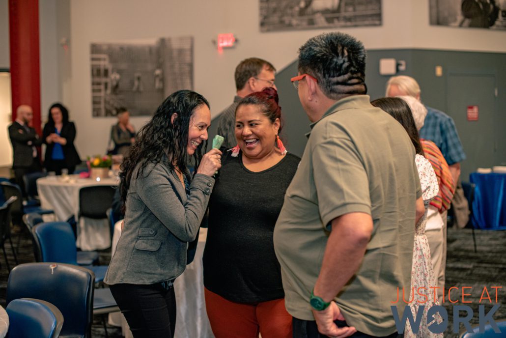 People laughing and talking at a gathering.
